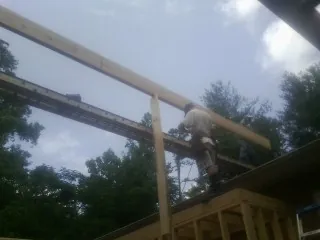 Carpenter setting a ridge beam over a new addition frame — Ice Dam Removal by Roofing Brothers in Grand Mound