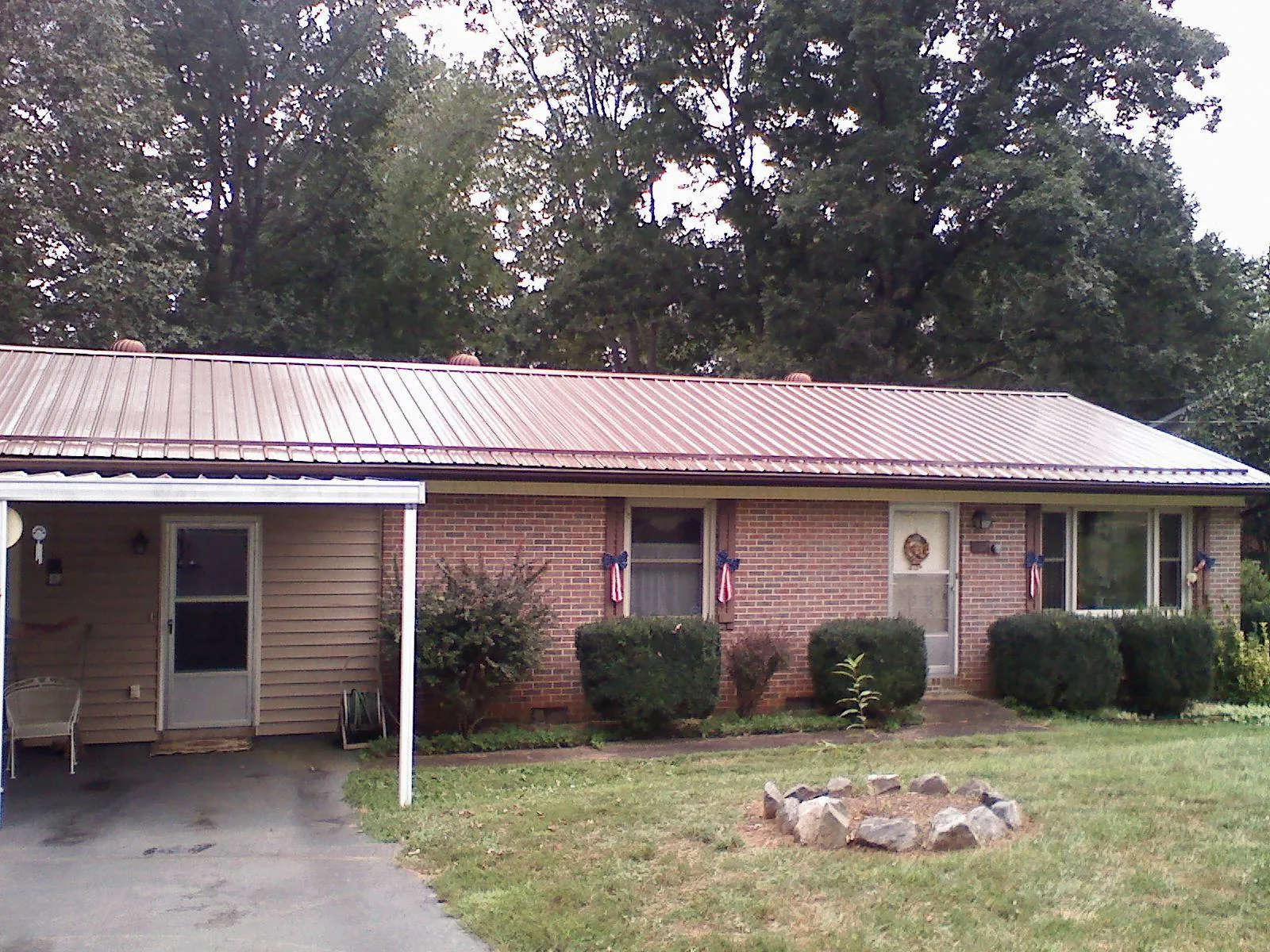 Bronze metal roof and carport on a brick ranch home — Roof Repair work by our crew in Grand Mound